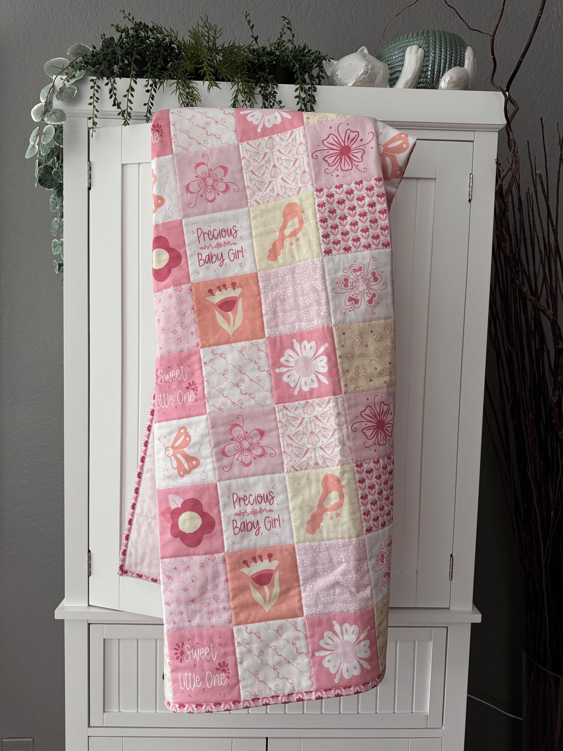 Quilt hanging over bookshelf door