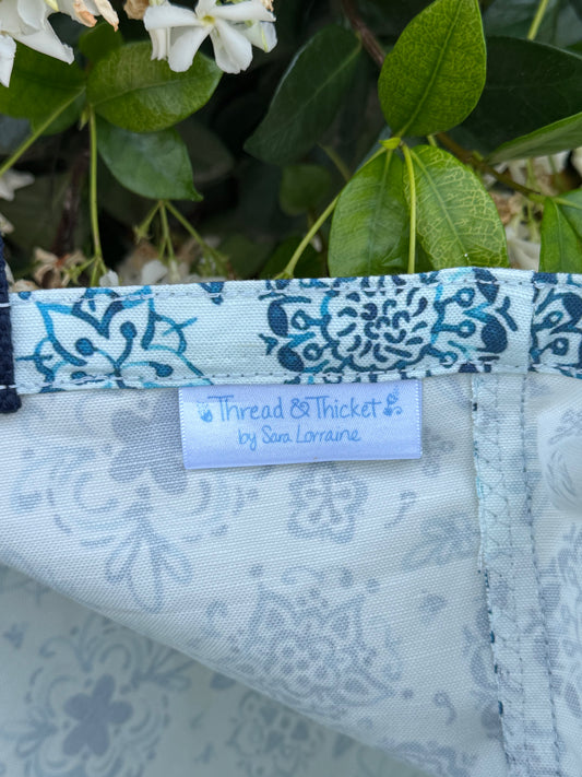 Artistic floral reusable tote bag close up fabric tag detail in blue